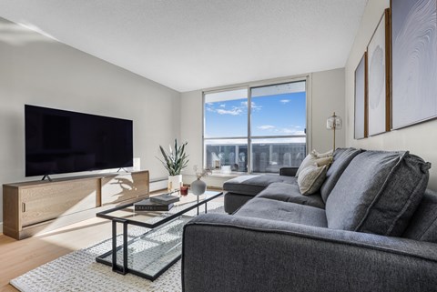 A modern living room with a grey couch and a flat screen TV.