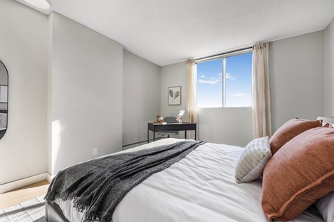 A bedroom with a large bed and a window overlooking the sky.
