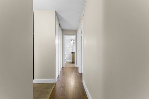 A long hallway with a white door at the end.
