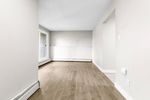A room with wooden flooring and white walls.
