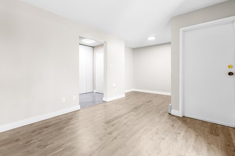 A room with a white door and a window with blinds.