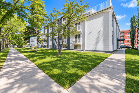 A white building with a green lawn in front of it.