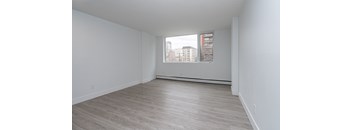 Empty room with a window overlooking a cityscape.