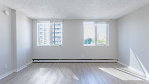A large empty room with a window overlooking a cityscape.