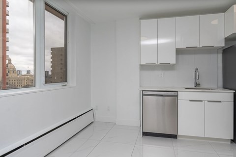 A kitchen with white cabinets and a stainless steel dishwasher.