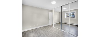 A room with a white door and a picture on the wall.