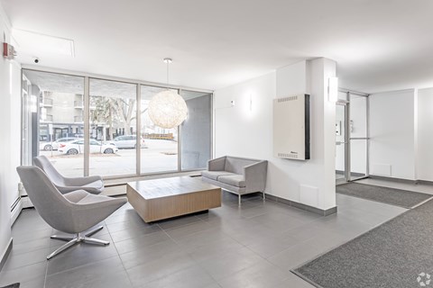 A modern living room with a grey chair and a white sofa.