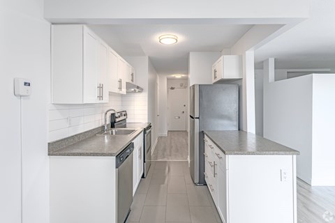 A kitchen with white cabinets and appliances.