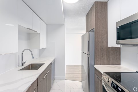 A modern kitchen with a stainless steel oven and white countertops.