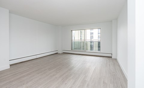 A room with a window and wooden flooring.