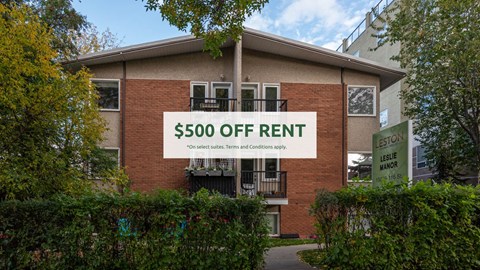 A brick building with a sign that says "$500 OFF RENT" in front of it.