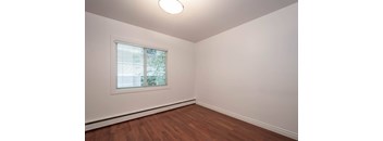 A room with a window and wooden flooring.