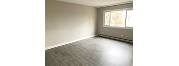 A room with a window and a grey floor.