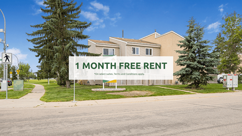 A sign offering a free one month rent is displayed in front of a house.