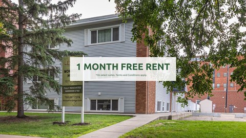 A sign offering a free one month rent is displayed in front of a building.