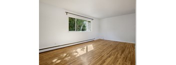 A room with wooden flooring and a window.