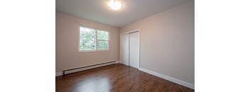A room with a window and a closed door.