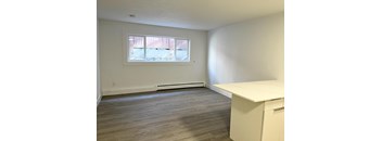 A room with a window and a white desk.