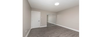A room with a white door and a mirror on the wall.