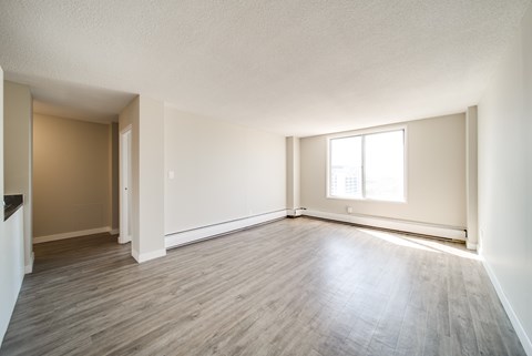 A room with wooden flooring and a window letting in natural light.