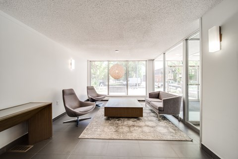 A living room with a brown sofa, grey armchair, and a coffee table.