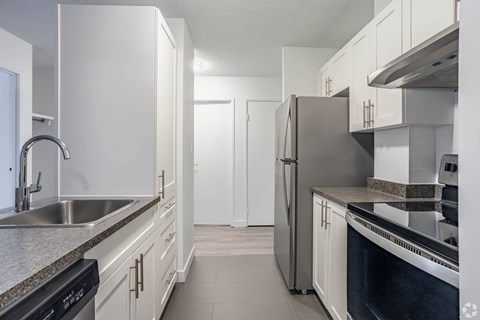 A kitchen with white cabinets and stainless steel appliances.
