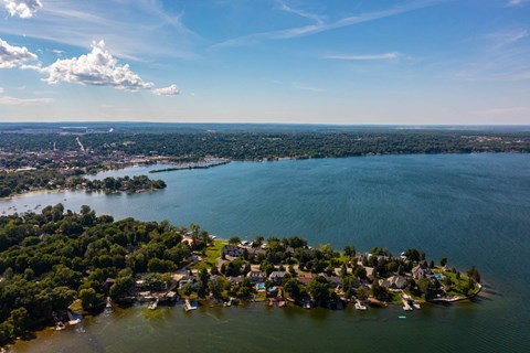 A small island with houses and boats surrounded by water. at The Grove  Apartments, Orillia, ON