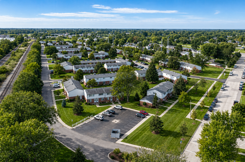 A bird's eye view of a residential area with houses, roads, and cars.