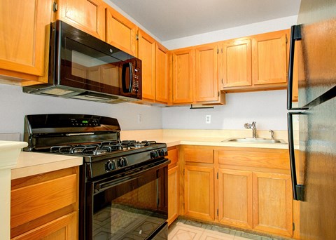 A kitchen with wooden cabinets and a black stove top oven.