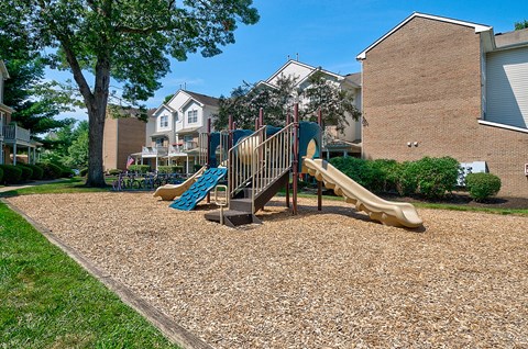 A playground with a slide and a wooden structure.