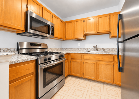 A kitchen with wooden cabinets and stainless steel appliances.