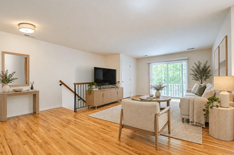 A living room with a wooden floor and furniture.