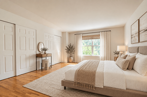 A bedroom with a large bed and a desk with a chair.