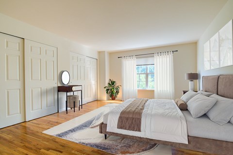 A bedroom with a large bed and a window with curtains.