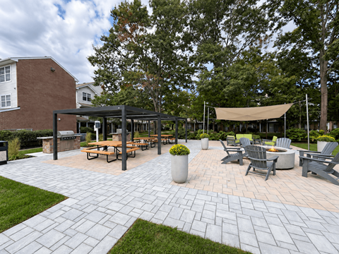A patio with a table and chairs is surrounded by trees.