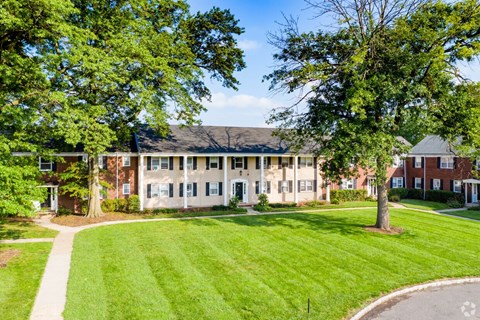 A large building with a green lawn in front of it.