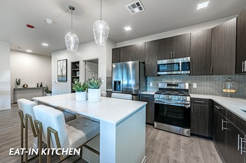 A modern eat-in kitchen with a large island and stainless steel appliances.