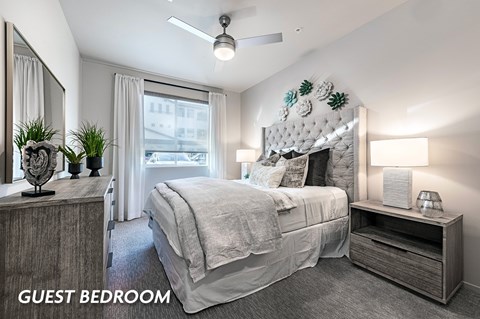 A guest bedroom with a large bed and a decorative headboard.