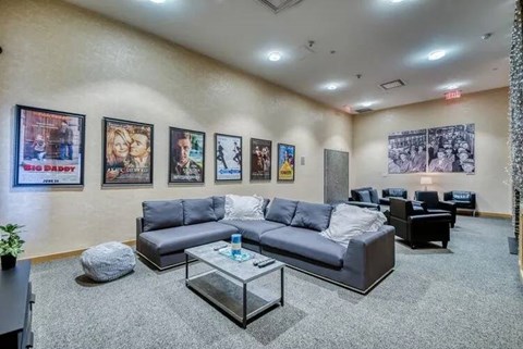 A living room with grey couches and a glass coffee table.