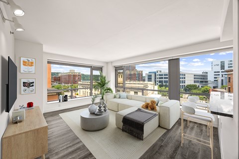 A modern living room with a large window overlooking the city.