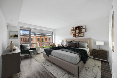 A bedroom with a large bed and a chair by the window.