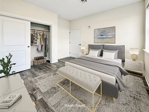 A bedroom with a large bed and a bench in front of it.
