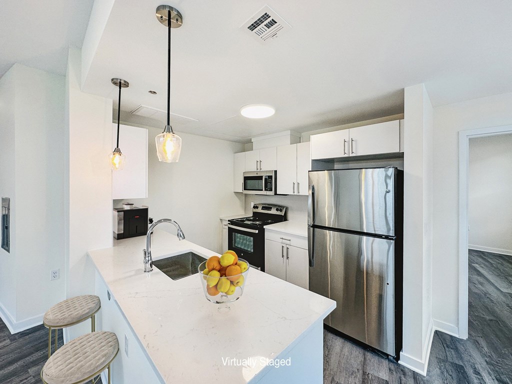 A kitchen with a white countertop and stainless steel appliances.