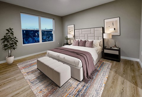 A bedroom with a large bed, a bench, and a potted plant.