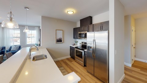 A kitchen with a white counter top and stainless steel appliances.