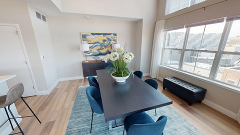A dining room with a table and chairs.
