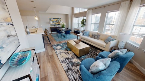 A living room with a blue couch and a rug.