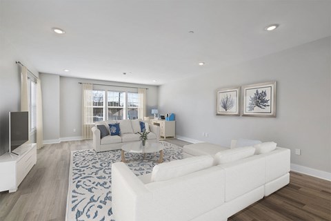 A living room with a white couch and a television.