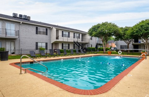 A swimming pool in front of apartment buildings.
