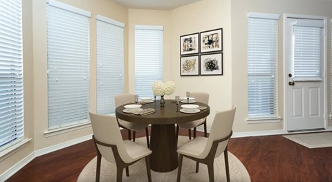 A dining room with a round table and chairs.